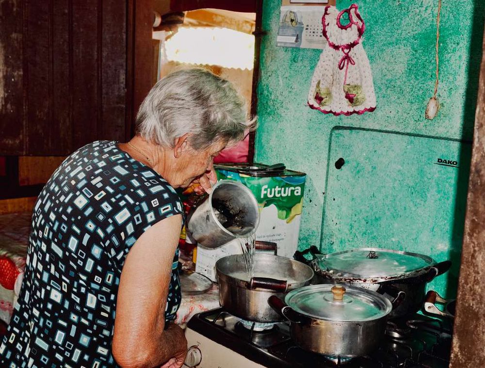 Avó de Eduarda cozinhando no fogão da casa da roça